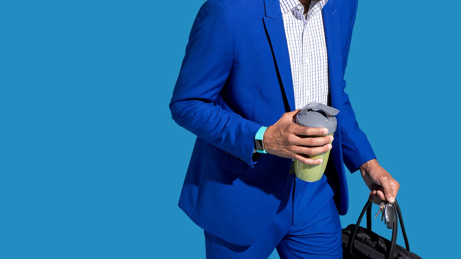 A man going to work with a travel cup filled with a Soylent Powder smoothie.